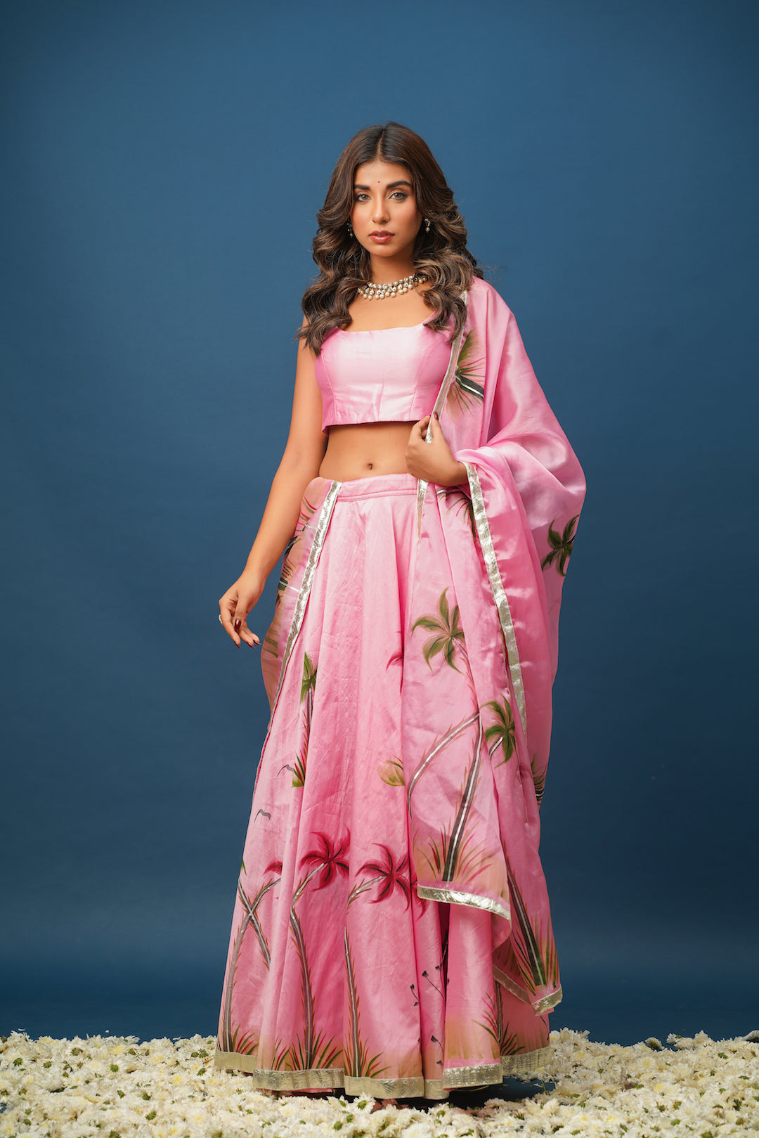 Full view of woman twirling in pink lehenga set for mehendi or wedding function

