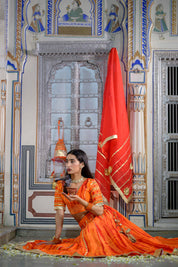 Model wearing festive orange lehenga from House of Baisa

