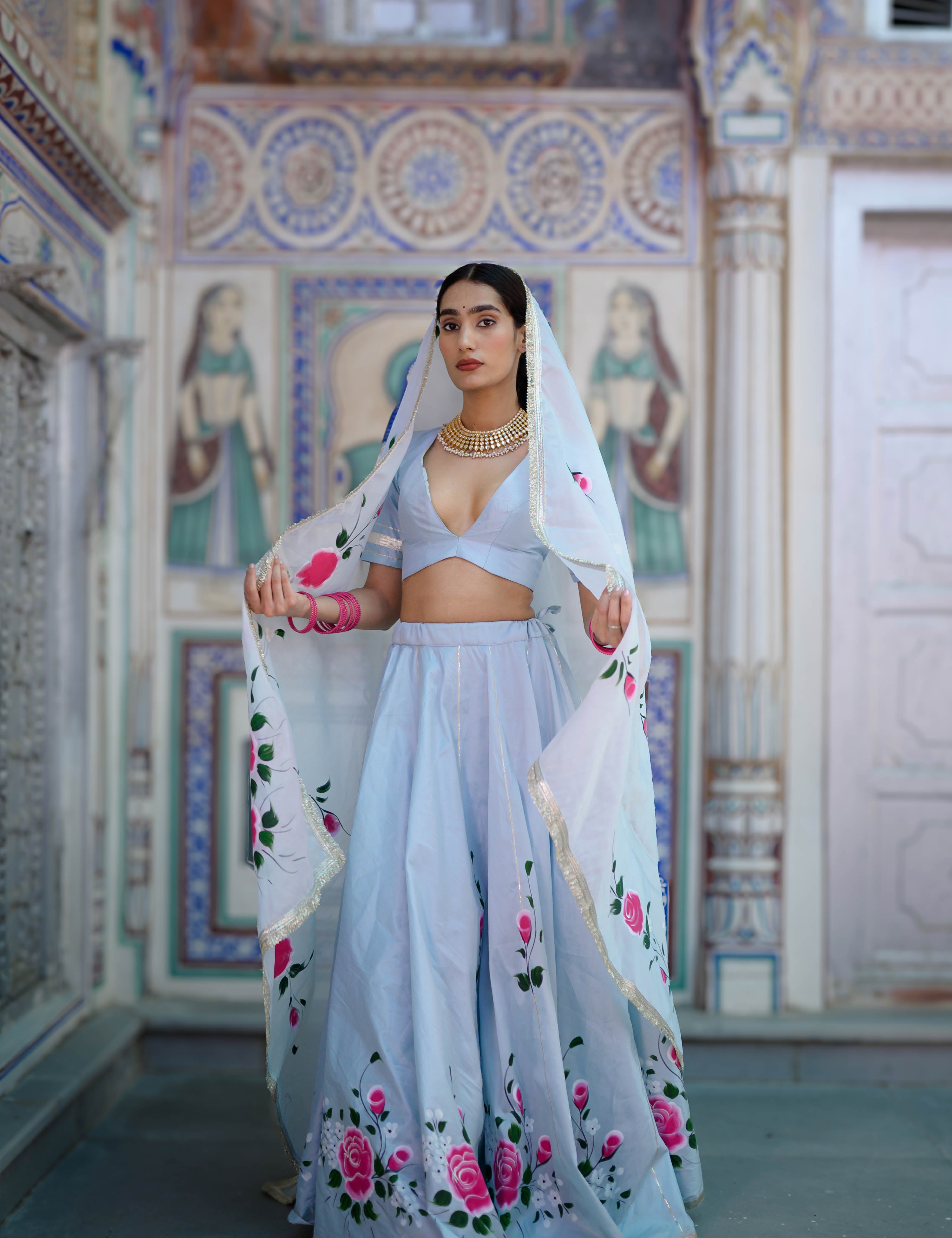 Hand-painted floral detailing on blue lehenga