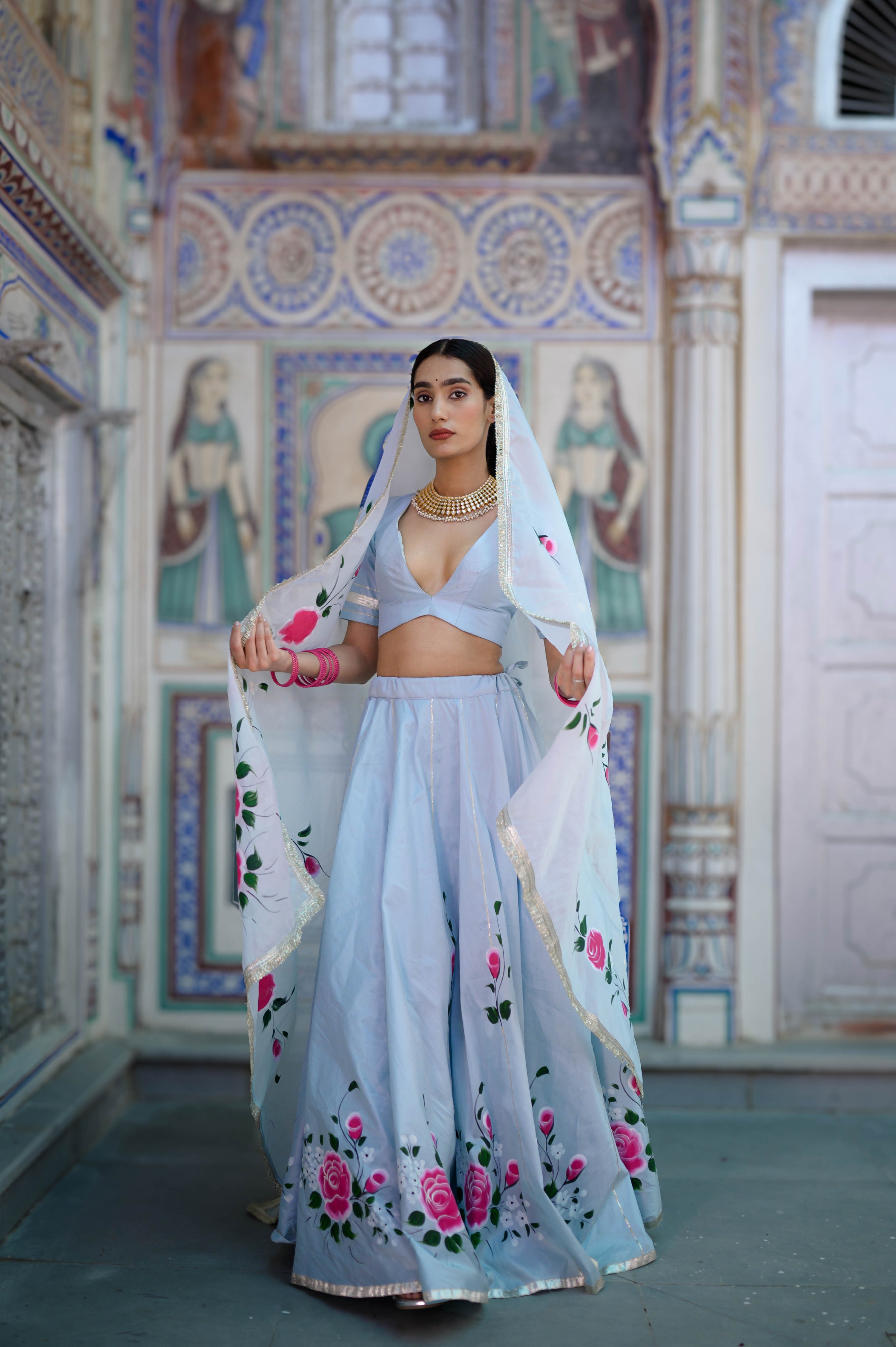 Hand-painted floral detailing on blue lehenga