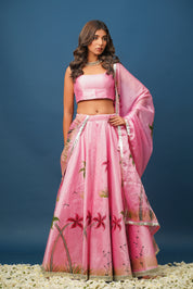 Model wearing Mandakini pink lehenga with floral hand-painted blouse and satin skirt

