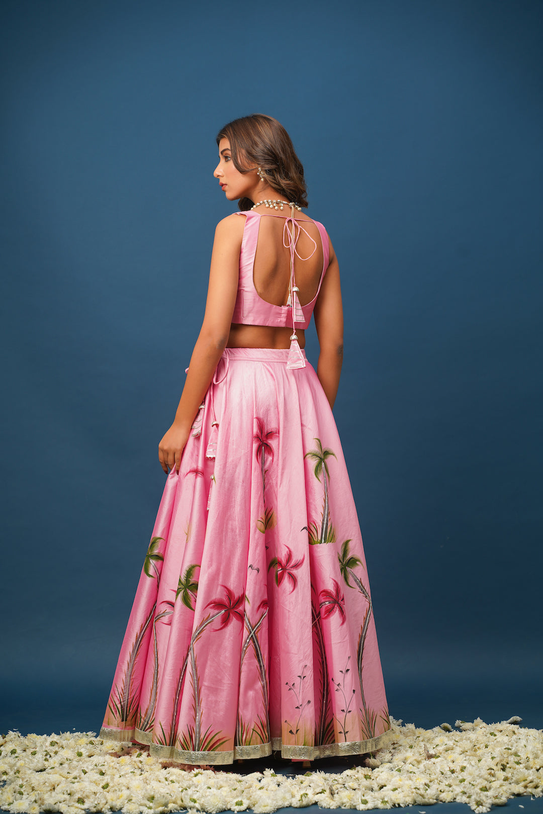 Mandakini pink lehenga flatlay showing satin texture and floral print details

