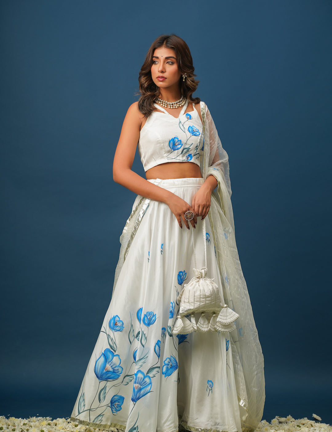 Woman wearing blue lehenga with white floral painting
