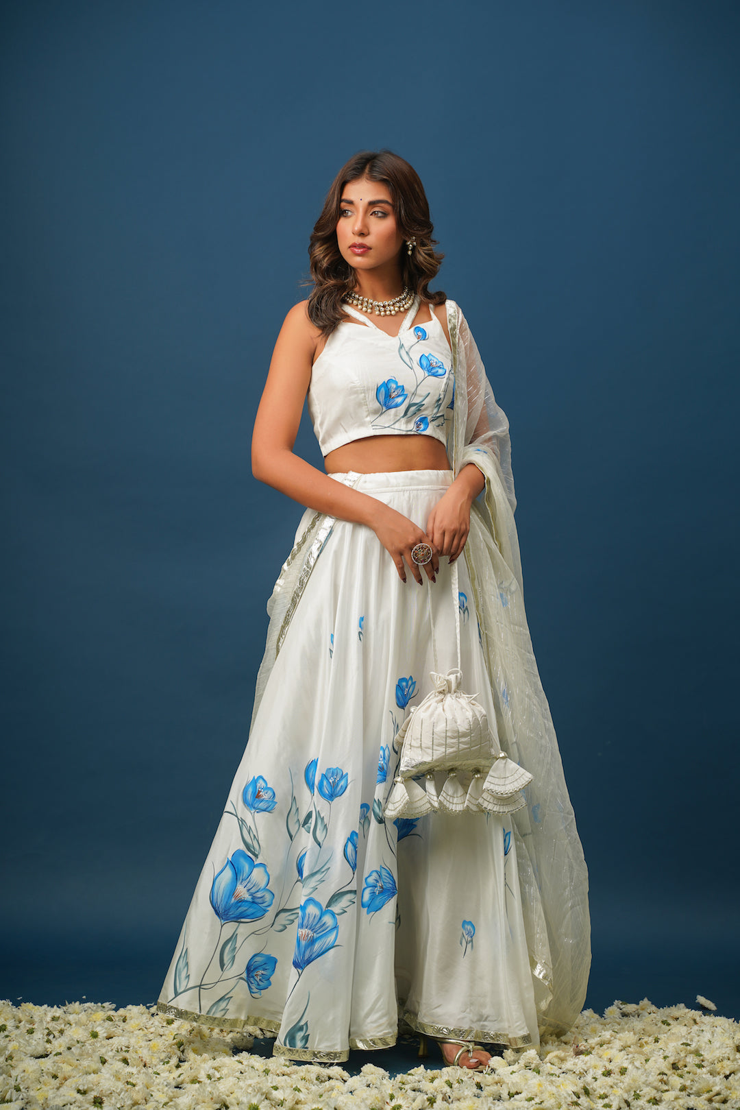 Woman wearing blue lehenga with white floral painting
