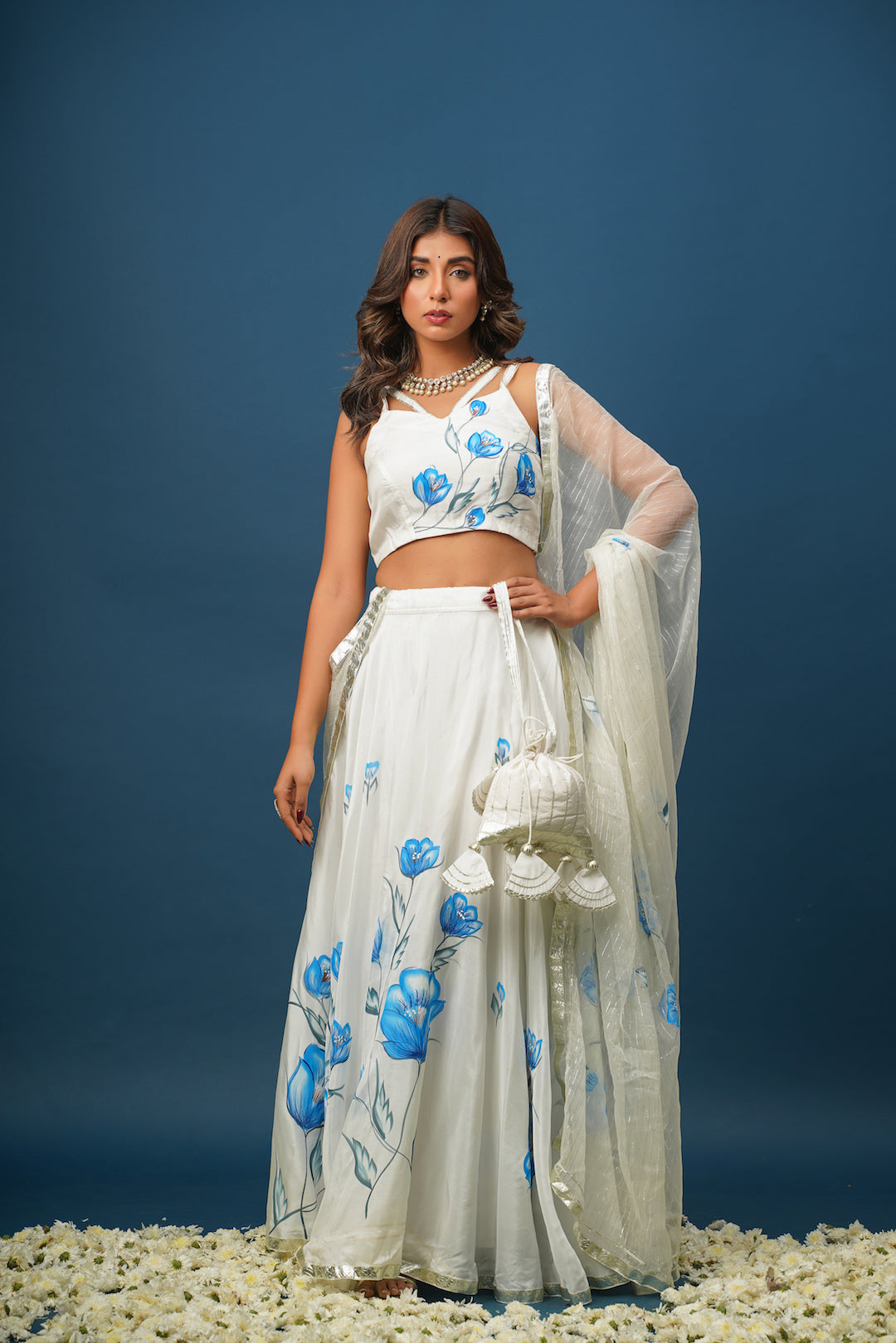 Woman wearing blue lehenga with white floral painting
