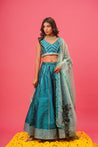 Full outfit view of teal lehenga with hand-painted details	