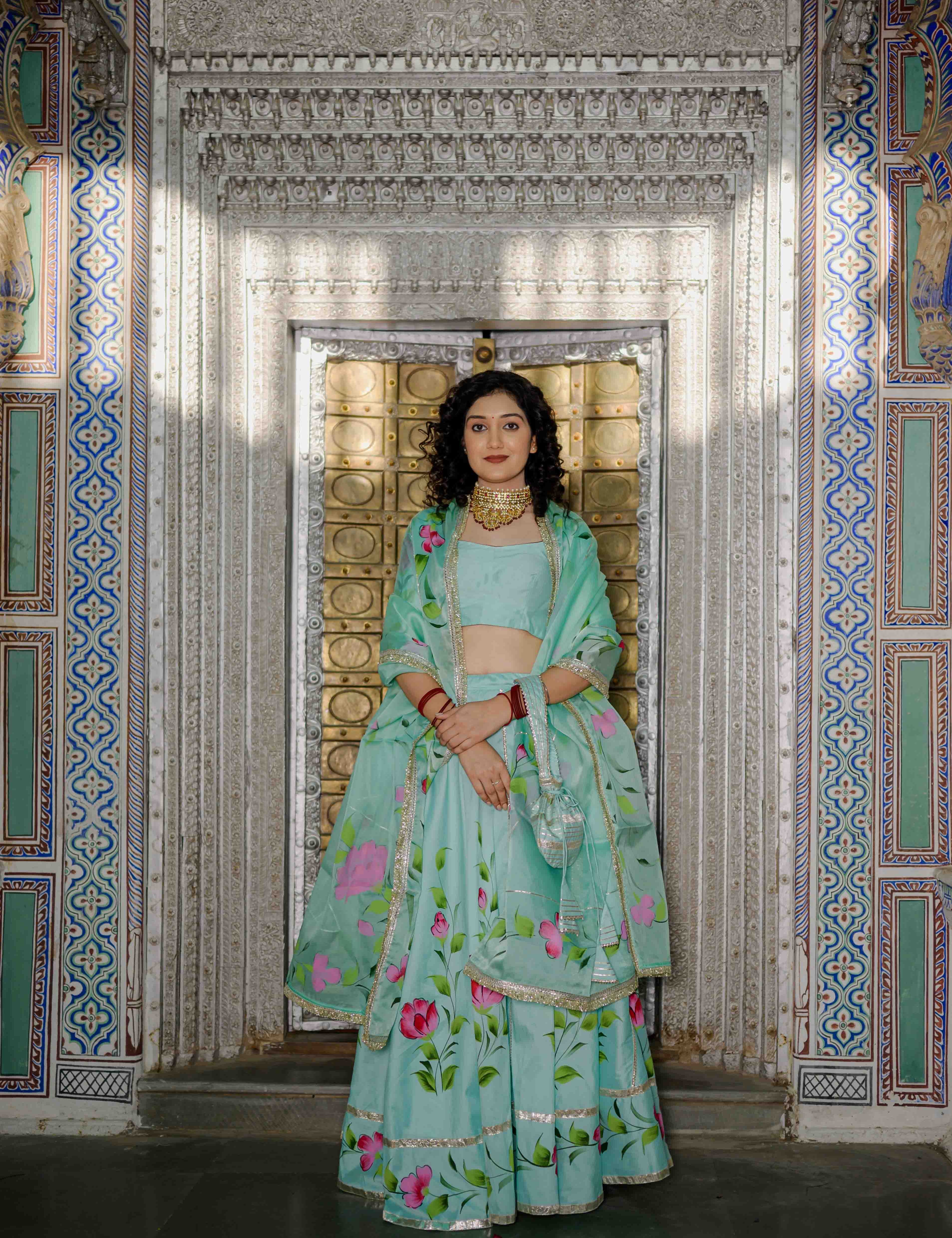 Woman wearing mint green floral satin lehenga with dupatta

