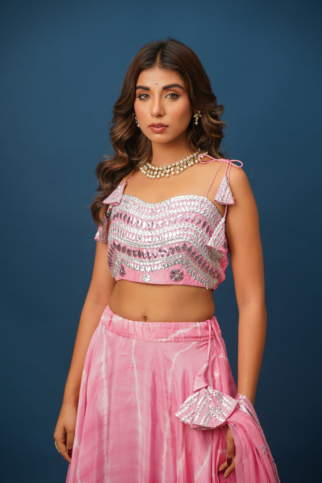 Close-up of gota detailing on pink lehenga skirt
