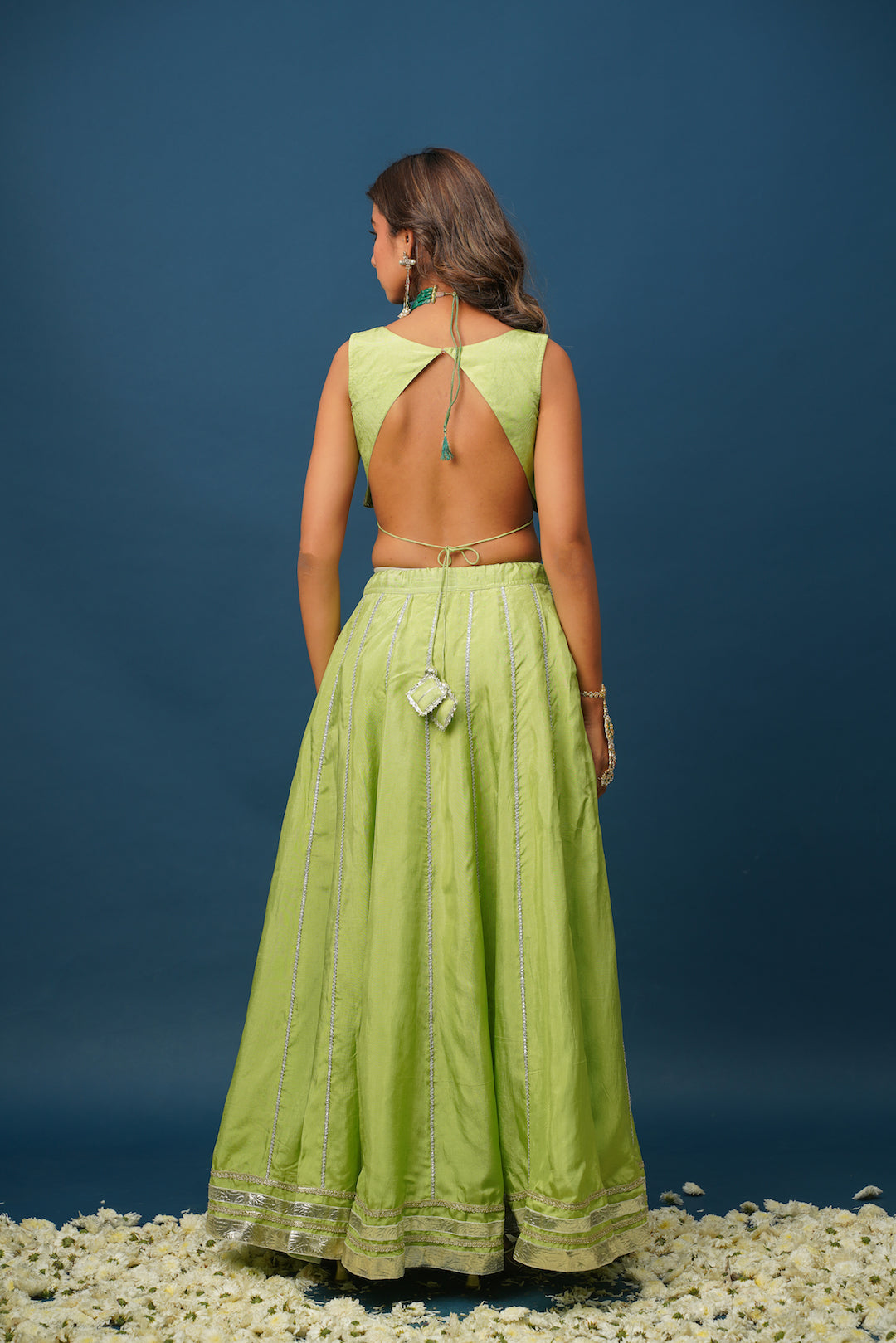 Flatlay of Maya green lehenga showing fabric texture and embroidery
