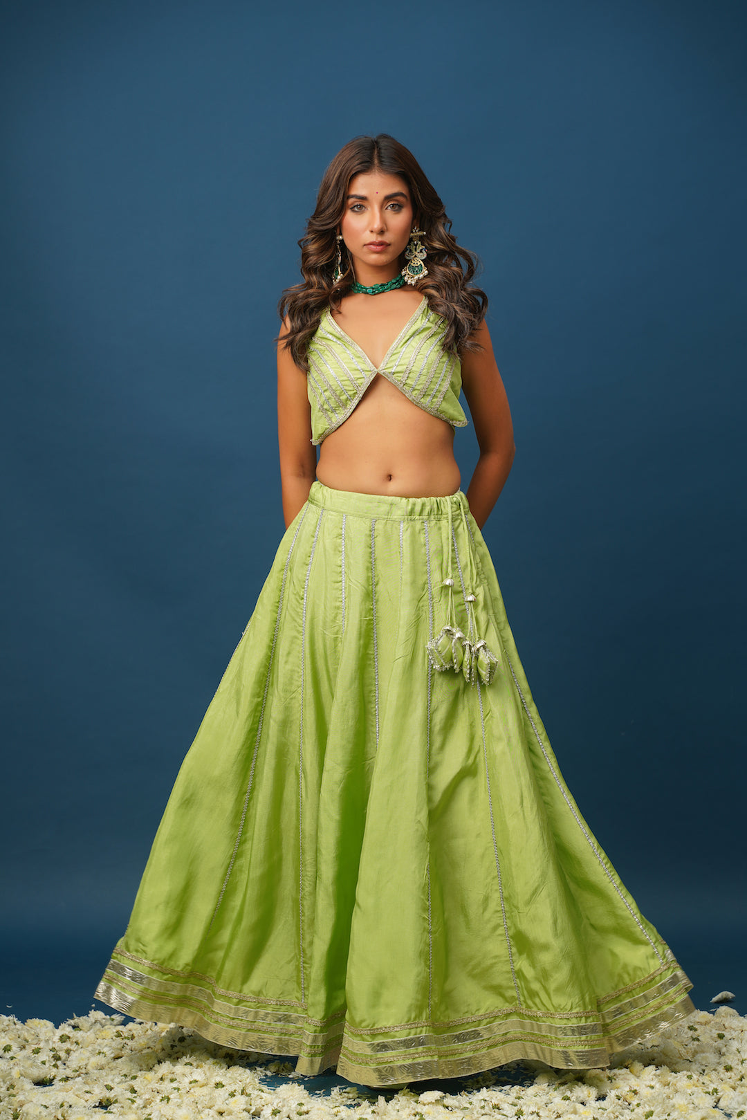 Full-length shot of woman wearing Maya green lehenga set with accessories
