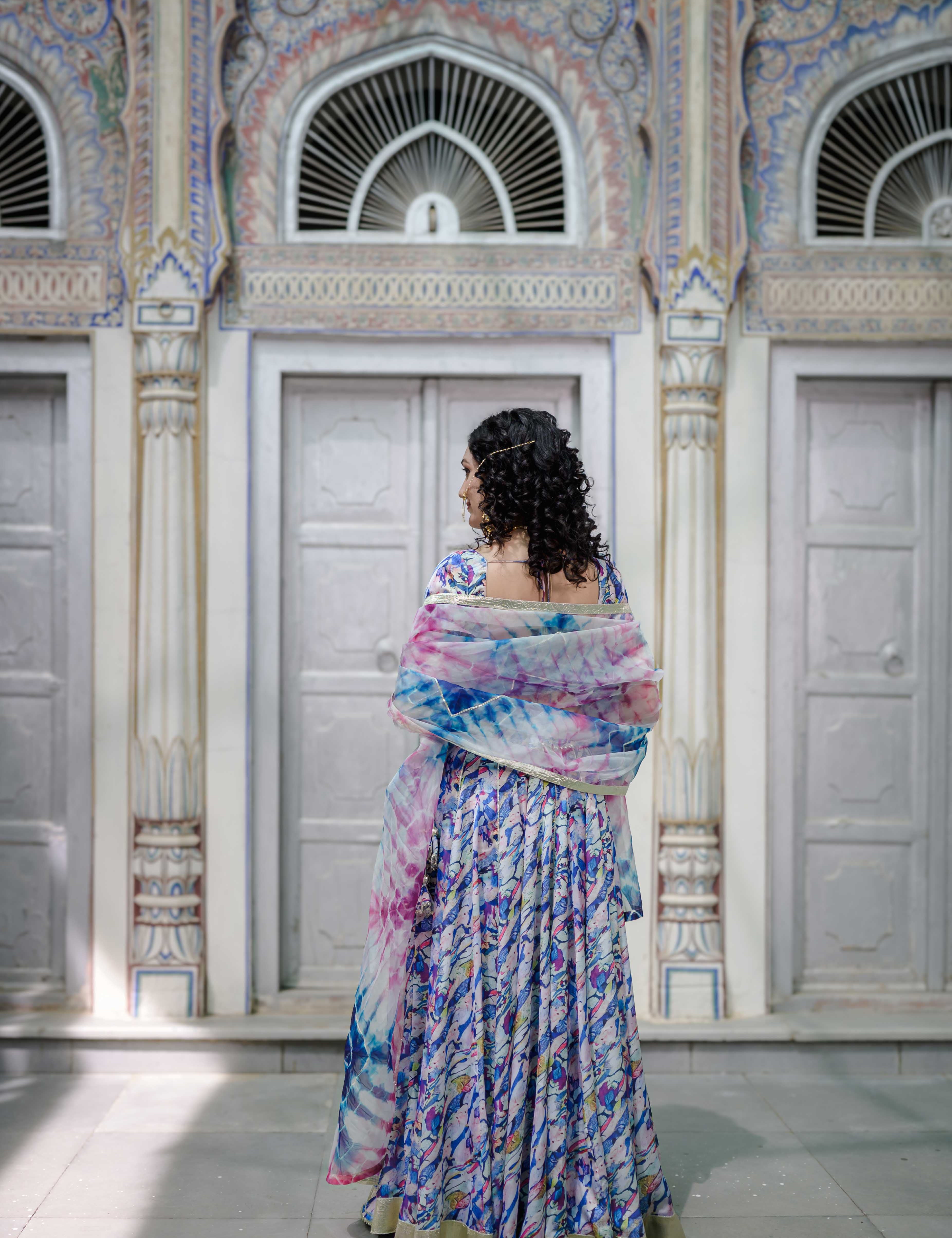 "Close-up of hand-painted blouse with delicate gota work on pastel satin fabric

