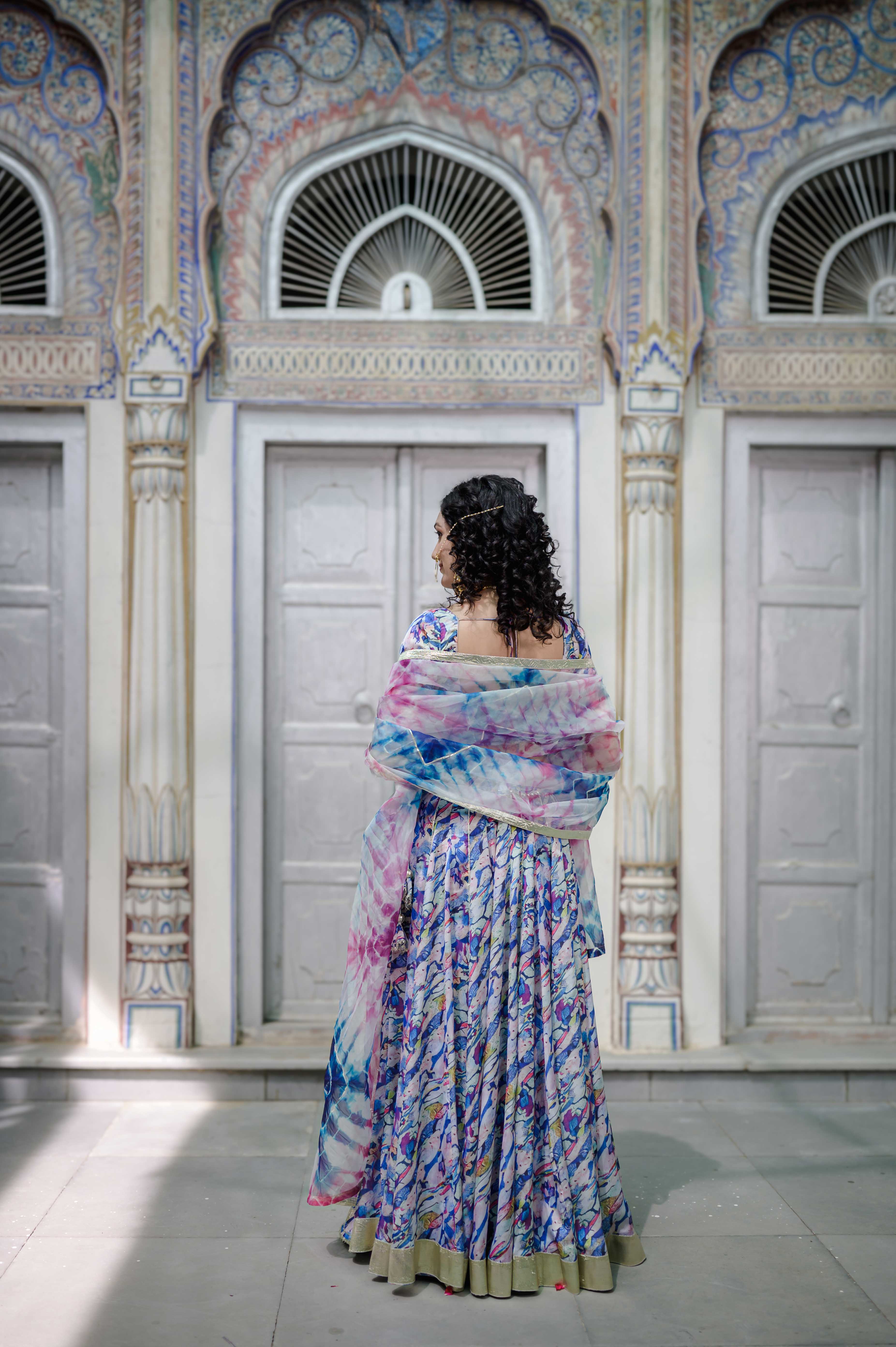 "Close-up of hand-painted blouse with delicate gota work on pastel satin fabric

