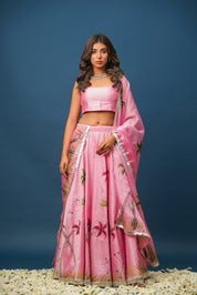Close-up of hand-painted floral designs on pink lehenga blouse and skirt


