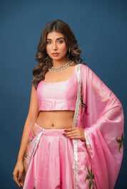 Elegant pink satin lehenga with organza dupatta styled for festive Indian celebration

