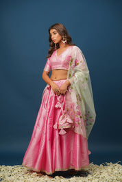 Woman wearing Rohini pink lehenga with floral hand-painting
