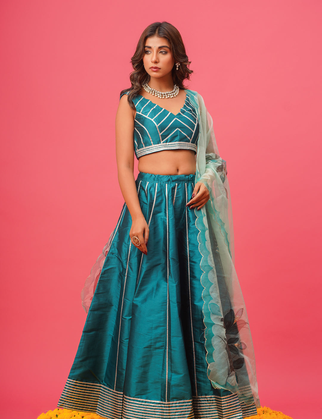 Close-up of floral hand-painting on teal lehenga	