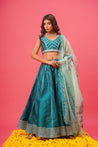 Model twirling in flowy teal lehenga with gota work	