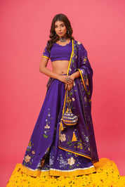 Model wearing violet silk lehenga with hand-painted floral motifs and organza dupatta

