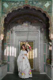 Model wearing white satin lehenga with floral hand-painted motifs

