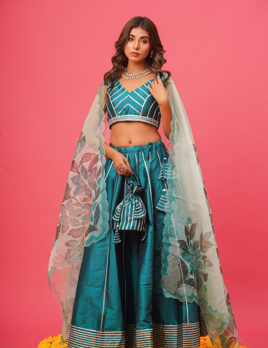 Woman wearing teal silk lehenga with net dupatta	